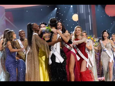 Miss USA R'Bonney Gabriel (back to camera), is hugged by other contestants after being crowned Miss Universe.