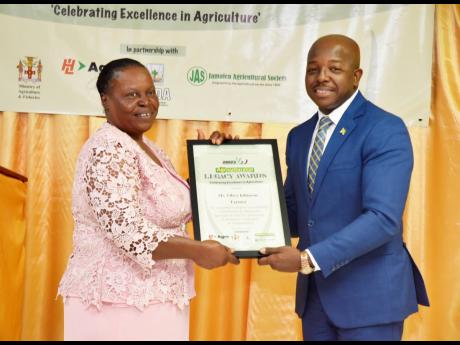 Olive Johnson (left), farmer, receives Agricultural Legacy Award from Pearnel Charles Jr, minister of agriculture and fisheries.