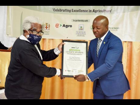 Paul Jennings (left), cattle nutritionist and livestock researcher, receives Agricultural Legacy Award from Pearnel Charles Jr, minister of agriculture and fisheries.