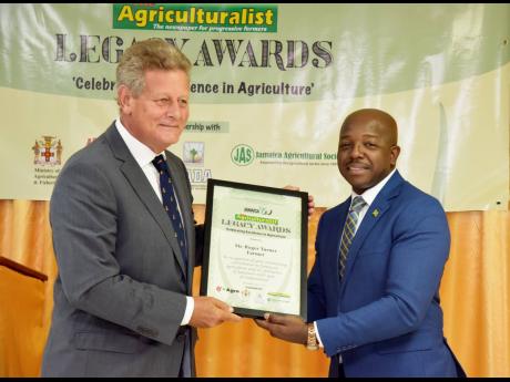 Roger Turner (left), a farmer, receives Agricultural Legacy award from Pearnel Charles Jr, minister of agriculture and fisheries.
