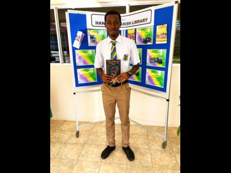 Rusea’s head boy Christopher Campbell displaying a copy of his first novel.