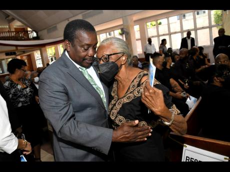 Robert Montague greets Effie Lakasingh, widow of businessman Seragh Lakasingh, at the thanksgiving service for the late businessman at the Andrews Memorial Seventh-Day Adventist Church on Hope Road in St Andrew on Monday.