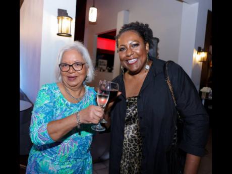 Scotia Group board member, Angela Fowler (left), and Marcette McLeggon, chief risk officer at Scotiabank, celebrate Jeffrey Hall’s tenure at the farewell party.