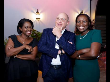 Pose off! The man of the moment, Jeffrey Hall (centre), sets the stage with his signature pose while Yanique Forbes-Patrick (left), vice president, public affairs and communications, and Michelle Wright, chief financial officer and chief administrative off