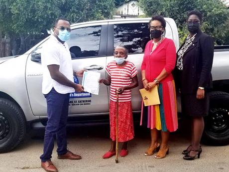 Chief Executive Officer (CEO) at the Registrar General’s Department (RGD), Charlton McFarlane (left), journeyed to the Maxfield Avenue home of Barbara Phillips to present her with a copy of her birth certificate recently. Also sharing the moment are Depu