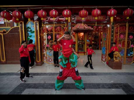 Children practice their dragon dance routines for the upcoming Chinese Lunar New Year celebrations outside the Hok Lay Kiong temple in Bekasi, Indonesia.