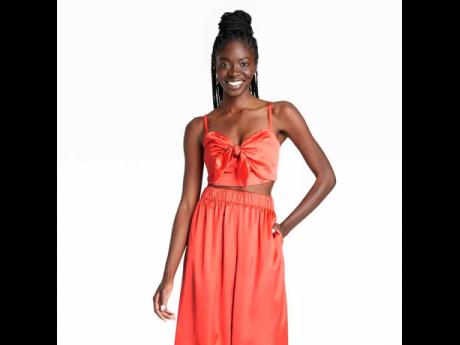 This orange satin bralette top with a bow detail, is paired with a matching mid-rise pull-on pants. 