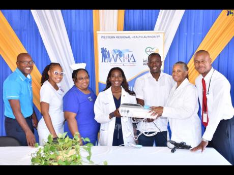Vice-President of Public Health Advocacy at US-based Northwell Health, Dr Sandra Lindsay (centre), hands over a cardiotocograph to the staff at the Noel Holmes Hospital in Lucea, Hanover. From left are CEO of the Noel Holmes Hospital, Carlington McLennon; 