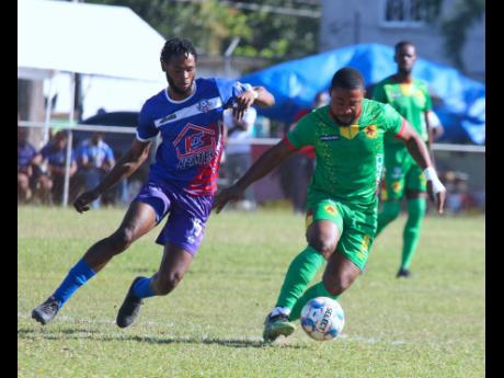 Humble Lion’s Dasha Satchwell (right) moves away from Portmore United’s Jahvon James during their Jamaica Premier League encounter at Effortville Community Centre yesterday. Humble Lion won 1-0.