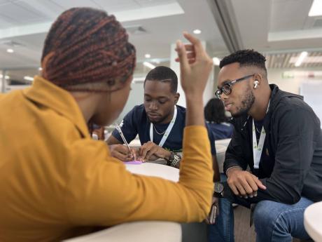 Jamaican students (from right) Kyle Campbell, Justin Newell, and Brianna Roper work together to come up with a creative pitch in one of their sessions in the Huawei Seeds for the Future programme integration trip. 