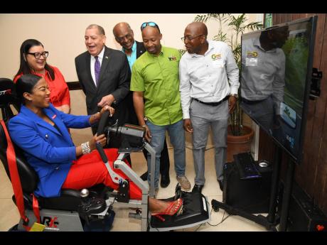 Tyheissa Williams, communications manager at Red Stripe, tests her skills on a driving stimulator during Grennell’s Driving School’s Crash Free 2023 Defensive Workshop at The Jamaica Pegasus hotel in New Kingston on Monday. Looking on are (from left) S