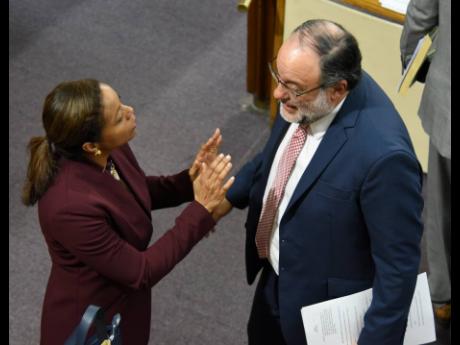 Marlene Malahoo Forte, minister of legal and constitutional affairs, engages in discussion with Opposition Leader Mark Golding after the adjournment of the sitting of the House of Representatives on Tuesday. 
