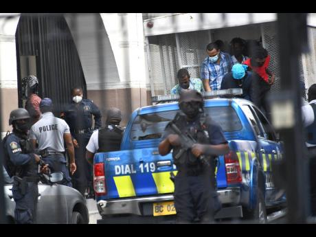 Police escort alleged members of the Clansman-One Don Gang to the Supreme Court building on September 20, 2021.