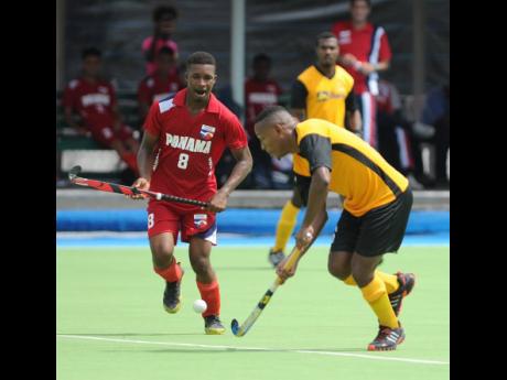Jamaica’s Nicholas Beach (right) dribbles by  Panama’s Angelo Boodie during the country’s 2017 CAC Games qualifier at the Mona Hockey field.