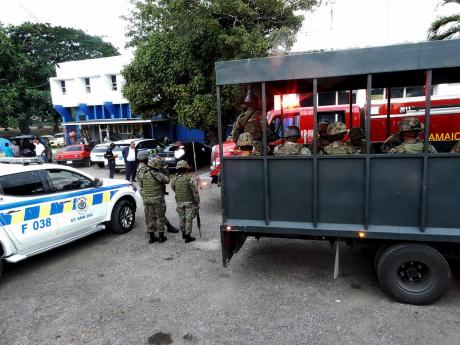 Cops, soldiers, and firefighters gather outside the Ocho Rios Police Station after prisoners became boisterous on Wednesday. 