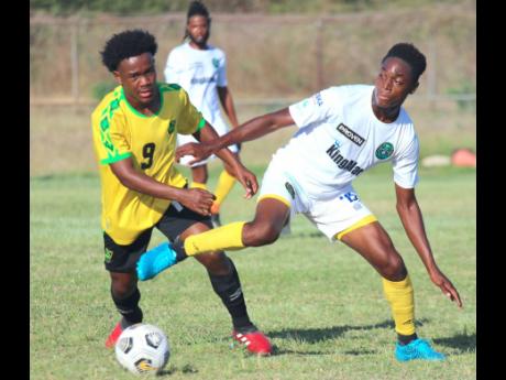 Jamaica Under-17 striker Ashton Gordon (left) battles with Courton Wright of Vere United during their practice game at the Wembley Centre of Excellence on Thursday. Vere United won 2-0. 