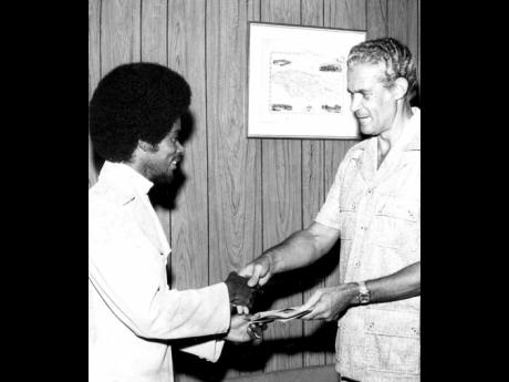R Max Romeo (left), presenting former Prime Minister Michael Manley with a copy of his hit, ‘Socialism is Love’ at his Devon Road office. The record was a present to the then prime minister on his 50th birthday in 1974.
