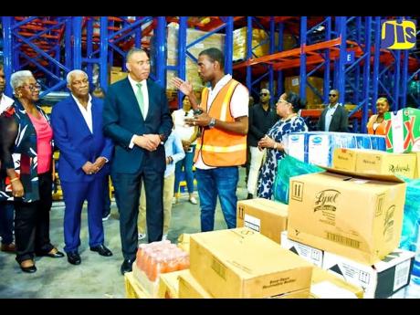 Prime Minister Andrew Holness (centre) is briefed by inbound supervisor, Cari-Med Group, Christopher Meikle (second right), during a tour of the company’s new distribution centre in Bernard Lodge, St Catherine, which was officially opened on Friday, Janu