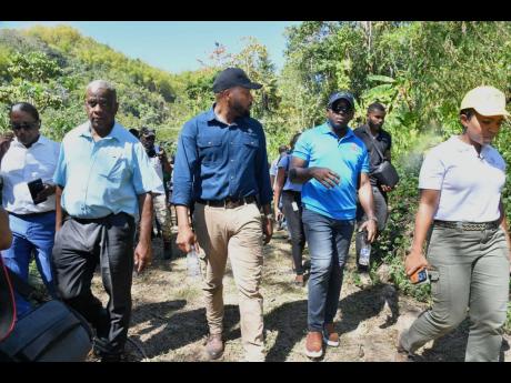 Entertainer Agent Sasco (centre, foreground) and Minister of Agriculture and Fisheries  Pearnel Charles Jr (second right, foreground) engage in discussion during last Thursday’s tour of Mulberry Valley Estate in Friendship Gap, St Mary.