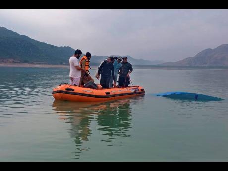 Rescue workers search for bodies after a boat with students capsized in northwest Pakistan on Sunday. 