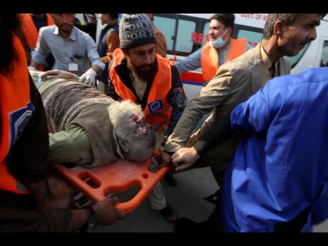 Workers and volunteers carry an injured victim of a suicide bombing to a hospital in Peshawar, Pakistan, on Monday.