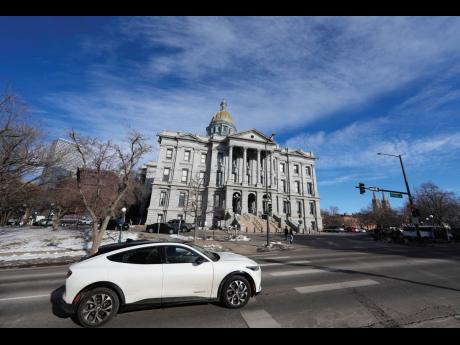 A 2022 Ford Mustang Mach E whips past the State Capitol on January 9, 2023, in Denver, Colorado.