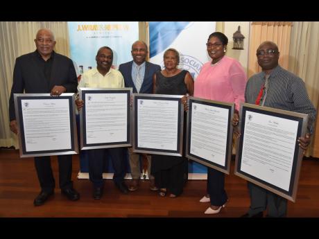 Press Association of Jamaica President Milton Walker (third left) poses with five media veterans feted by the organisation during a luncheon at Alhambra Inn in Kingston Wednesday. The awardees are (from left) Clevans Wilson, Keith Campbell, Pat Riley, Maxi