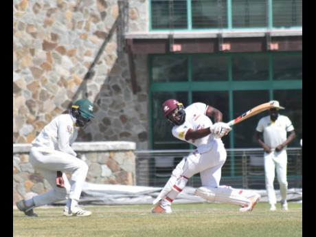 Leeward Islands Hurricanes captain Jahmar Hamilton plays a slog sweep while Jamaica Scorpions fielder Kirk McKenzie takes evasive action during their West Indies Championship match at Coolidge in Antigua yesterday.
