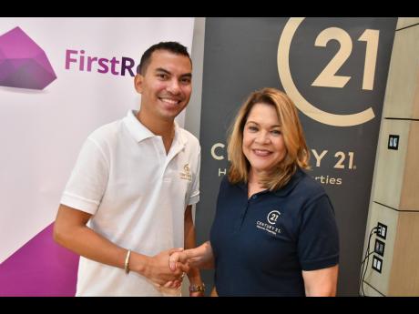 Directors Jordan Chin and Deborah Cumming shake hands on Thursday, February 2, 2023, at the announcement of the deal between First Rock and Century 21 Jamaica, at the AC by Marriott Hotel in New Kingston.
