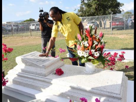 Minister of State in the Ministry of Culture, Gender, Entertainment and Sport, Alando Terrelonge, lays a wreath on the grave of Dennis Brown during the celebration marking the 66th anniversary of his birthday and wreath-laying ceremony at the National Hero