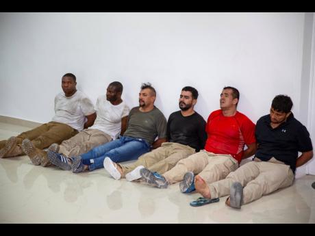 Suspects in the assassination of Haiti’s President Jovenel Moise, among them Haitian-American citizens James Solages (left), and Joseph Vincent (second left), are shown to the media at the general direction of the police in Port-au-Prince, Haiti, on July