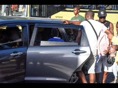 A child boards a cab in downtown Kingston on Thursday. Commuters 12 years old and younger have begun to find it difficult to travel on public transport, with some taxi operators refusing to risk receiving a $5,000 ticket for child seat traffic breaches.