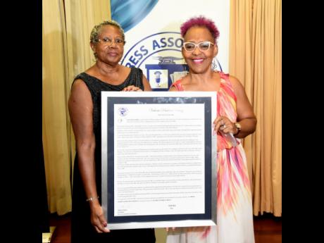 Gillian Haughton (right), first vice-president of the Press Association of Jamaica, presents a citation to Pat Riley, Jamaica’s first camerawoman.