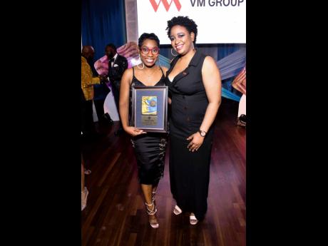 Gleaner reporter Kimone Francis (left), who took home two awards including the GraceKennedy Carlton Alexander Award for Finance and Business, poses with Denise Dennis, assistant manager, group corporate affairs and communication, VMBS, after receiving the 