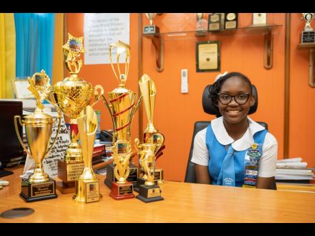 Jessie Ripoll Primary student Courtney Greaves is a picture of joy as she displays her haul of eight trophies from the Global Poetry Foundation's 2023 Poetry Competition. Greaves entered several poems across 15 categories. 
