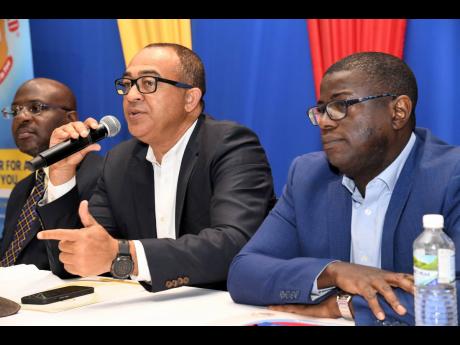 Dr Christopher Tufton (centre), minister of health and wellness, addresses a press conference on National Health Fund card benefits at The Jamaica Pegasus hotel in New Kingston. He is flanked by NHF Acting Chairman Shane Dalling (left) and CEO Everton Ande