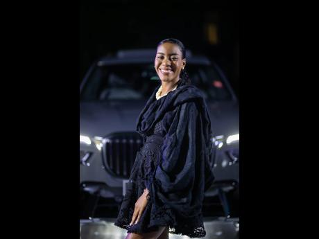 Savannah Peridot, business manager at the University of the West Indies, Mona, poses with the newly unveiled BMW X7.