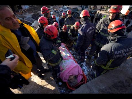 Rescue teams evacuate a survivor from the rubble of a destroyed building in Kahramanmaras, southern Turkey, Tuesday. A powerful earthquake hit southeast Turkey and Syria early Monday, toppling hundreds of buildings and killing more than 7,200.