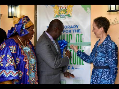 Sierra Leone Minister of Tourism and Culture Dr Memunatu Pratt (left) and Jamaica's Foreign Minister Kamina Johnson Smith look on as Sidique Wai, Sierra Leone high commissioner to Jamaica, cuts the ribbon to mark the opening of a new consular office in Red