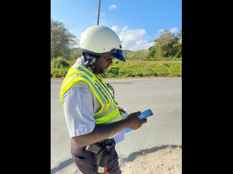 Constable Ryan Reid uses a portable machine to access data under the new ticketing system during the traffic operation.