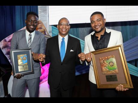 Charles Douglas (centre), director, regulatory affairs at Flow, shares congratulatory fist bumps with Young Journalist of the Year 2022, Romardo Lyons (left) of The Jamaica Observer, and Journalist of the Year 2022, Giovanni Dennis from the RJRGLEANER Grou