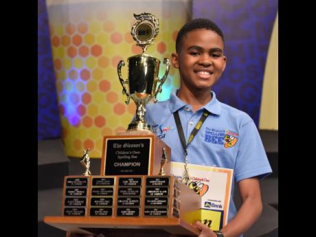 Taevion Morgan holds The Gleaner’s Children’s Own Spelling Bee trophy after he spelt the championship word H-E-B-D-O-M-A-D-A-L correctly on Wednesday.