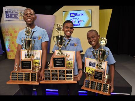 The Gleaner’s Children’s Own Spelling Bee champion Taevion Morgan is flanked by Johnathan Bailey (left), who came second, and Nathan Bailey, who placed third. 
