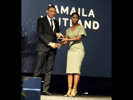 Jamaila Maitland receiving The Prime Minister’s National Youth Award for Excellence in national leadership from Prime Minister Andrew Holness on the evening of Saturday, February 4, on the lawns of Jamaica House in St Andrew.