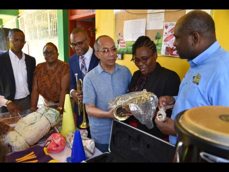 National Security Minister Dr Horace Chang (centre) presents a saxophone to Trevine Donaldson-Lawrence (2nd from right), principal of the Grange Hill High School, at a function held at the school on Friday, February 10. Others sharing in the occasion (from