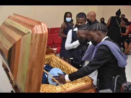 Relatives of Donovan Cunningham view his body inside Perry’s Funeral Home Chapel in Spanish Town, St Catherine, yesterday. Cunningham, who worked with the RJRGLEANER Communications Group, fainted on the job in December 2022 and was rushed to the Kingston