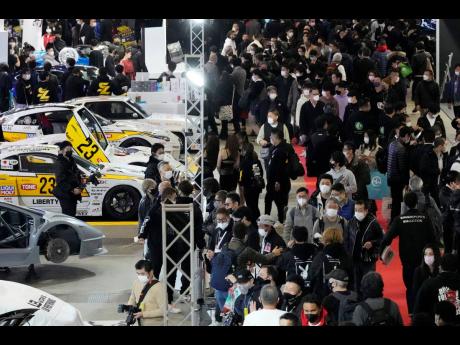 Guests visit booths at the Tokyo Auto Salon, an industry event similar to the world’s auto shows. 
