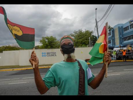 A man protests outside the British Council in Kingston, to demand an apology and slavery reparations during a visit to the former British colony by the duke and duchess of Cambridge, Prince William and Kate in March 2022.