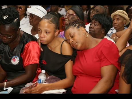 Wendy Whittick (right), mother of the late Brandon Small, receives support from her daughter Mikalah Stewart (centre) and Sharon Heslop-Royal, widow of the late Lincoln Royal, during Small’s funeral at the Red Hills Church of God of Prophecy in Clarendon