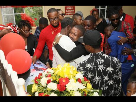 Tearful men seek consolation at the funeral for late security guard Brandon Small on Saturday.